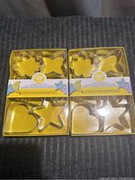 Two unopened Wilton cookie cutter sets with 6 cutters each in clear packaging.