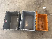 Top-down view of three crates showing one orange open crate and two gray crates with open tops inside