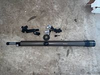 Photo of the Galileo telescope main tube laid horizontally on the floor with multiple detachable components arranged nearby. The telescope lacks its supporting legs.