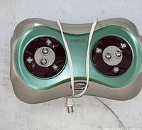 Top view of the Homedics Shiatsu Foot Massager showing two circular massage areas with chrome nodes and attached power cord.