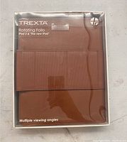 Front view of Trexta Rotating Folio case in original packaging with clear front showing the brown case inside.