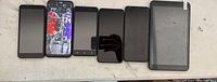 Photo showing 5 black Android smartphones and 1 Android tablet arranged side by side on a surface.