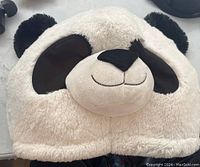 Front view of plush panda mascot head showing black ears, eye patches and smiling face