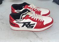 Side view of pair of red, white and black Rockstar branded sneakers, size 9.