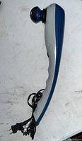 Side view of WAHL handheld electric back massager showing ergonomic handle and blue massage head with attached power cord.