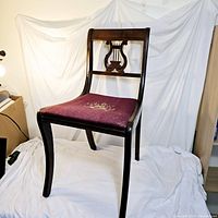 Full view of the wooden lyre harp back chair showing seat, backrest and legs.