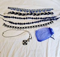 Photo showing all jewelry items laid out including 4 bracelets, pendant necklace, and blue pouch.