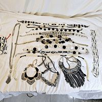 Overview of all vintage black themed costume jewelry necklaces laid out on a white surface showing variety of styles and designs