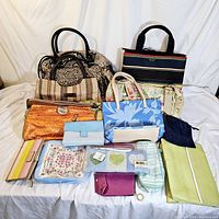 Photo showing a collection of 13 vintage purses and bags in various colors, sizes, and styles arranged on a white backdrop.