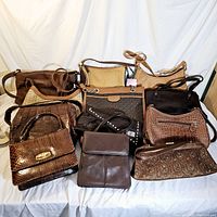 Wide angle photo showing all 10 handbags in various shades of brown, different textures including embossed croc and snakeskin patterns, woven fabric, and leather looks