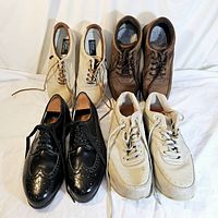 Four pairs of men's shoes arranged in two rows on a white background showing overall condition and color variations