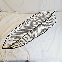 Long leaf shaped metal basket with wire construction, viewed from an angled side showing depth and detailed vein-like wire lines