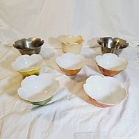 Overview of all eight bowls: 5 ceramic lotus rice bowls in green, yellow, orange, red and white, 2 small silver lotus bowls, and 1 yellow flower leaf pot with tulip design.