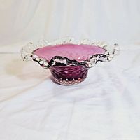 Side and angled view showing cranberry color, hobnail texture, and clear ruffled edge.