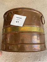 Full side view of the bucket showing the brass band and two large side ring handles