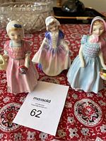 Three Doulton porcelain figurines side by side showing colors and detail