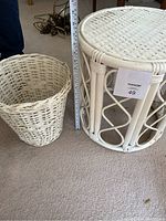 Overall view of the white wicker basket and matching white wicker side table, shown next to a measuring tape for scale.