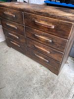 Front angle showing eight drawers and wooden handle details with worn finish and scratches on surface.