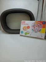 Photo shows neutral tone baby bassinet and boxed Bright Starts Flamingo Vibes baby bouncer packaging.