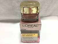 Front view of L'Oréal Paris Age Perfect Cell Renewal Rosy Tone Moisturizer jar on top of the box showing branding and product name.