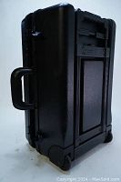 Side view showing black hard shell case with side handle