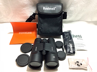Full set showing binoculars with lens covers, carrying case, quick start guide, neck strap, and lens covers laid out.