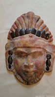 Front view of the terracotta mask showing details of copper ornament on headdress and earrings