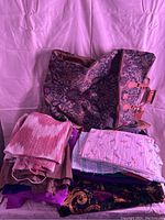 Printed carry case open showing fabric pieces beside it on pink background