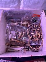Box with brass lion head door knocker, porcelain doorknobs, and various door hardware pieces