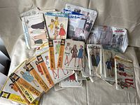 Top-down photo showing an assortment of vintage sewing pattern envelopes from various brands