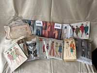 Photo showing assortment of vintage sewing patterns including Vogue, Simplicity, and McCall's brands with various styles.