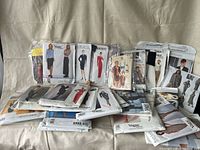 Wide view of multiple vintage Vogue designer sewing pattern envelopes arranged showing various fashion designs by famous brands