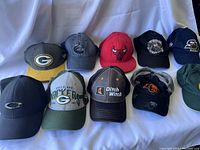 Overview of all 10 assorted caps laid out front facing with visible logos.