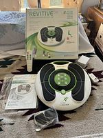 Full view of Revitive Circulation Booster device with remote, adapter, user manual, and original box.