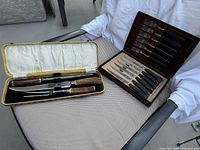 Photo of the full lot showing carving set and boxed cutlery set with knives and forks