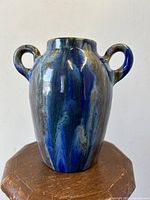 Front view of twin handled crystalline glaze pottery vase with blue and gray colors, showing its height and handles.