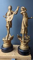 Pair of two Orientalist Art Nouveau bronzed metal statues with wood bases and Musique labels, viewed from front.