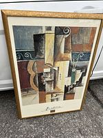 Framed art poster titled 'Violin and Guitar' by Pablo Picasso, showing the full artwork in cubist style with gold frame.