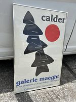 Full view of framed poster leaning against a white background