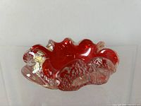 Side and top view showing the ruby red aventurine center with clear glass edges and sparkling spangled inclusions on the organic ruffled rim.