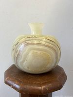 Front view of vintage swollen marble vase showing the swirled natural patterns in beige and cream.