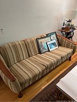 Full view of sofa showing overall shape, upholstery and wood frame