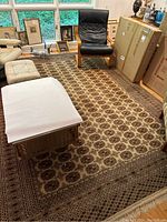 Full view of the large wool area rug on a hardwood floor, partially covered by furniture and boxes.