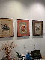 Three framed Asian art prints hung on wall showing different traditional figures in detailed attire with calligraphy and seals.