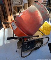 Left-side perspective of mixer showing drum, frame, wheels and motor housing