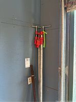 View showing two red heavy duty metal clamps mounted on metal pipe with rebar bundle next to them