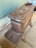 Angle view showing full stove body, legs, top burner plates and decorative door.