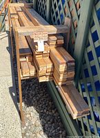 Stack of bundled yellow cedar boards with handwritten sign and length markings