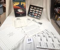 Overview of box, rule books, and various game sheets including hex mode sheets spread on fabric surface