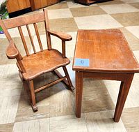 Photo shows child's maple wood rocking chair next to rectangular table on tiled floor, highlighting condition and size.
